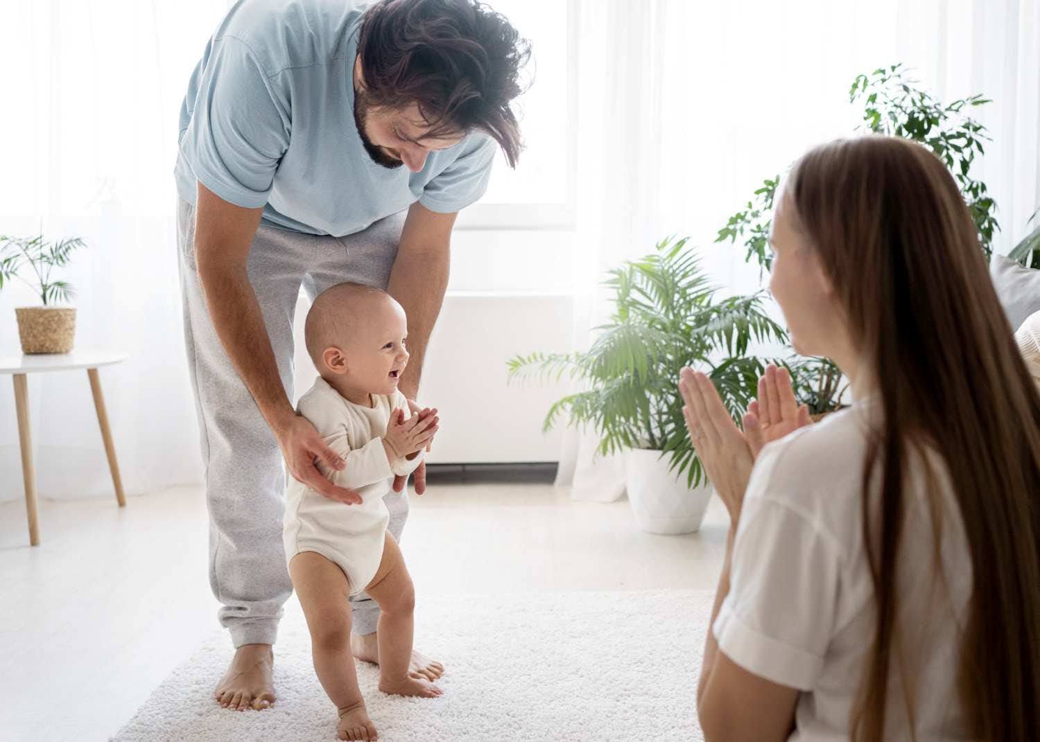 ลูกน้อยกำลังก้าวเดินครั้งแรกโดยมีพ่อแม่ช่วยจับมือและให้กำลังใจ