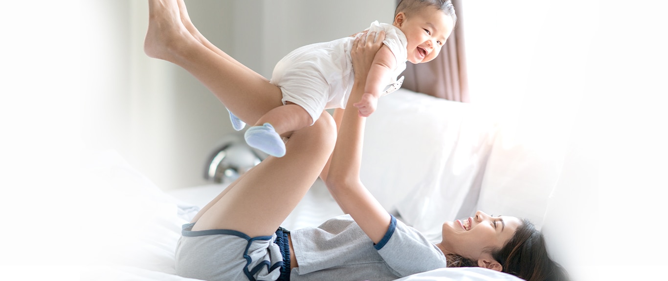 คุณแม่เล่นกับลูกน้อยบนโซฟาอย่างมีความสุข